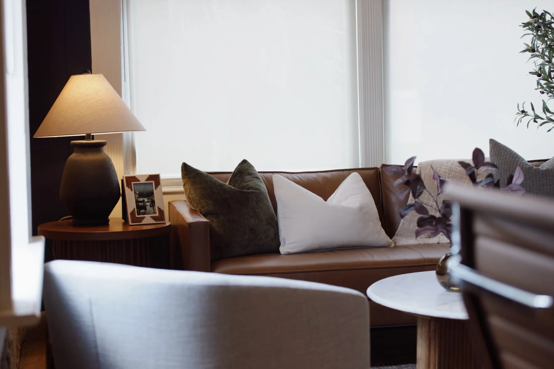 Office lounge with a leather sofa and lamp-lit side table — commercial interior design in Valdosta, GA