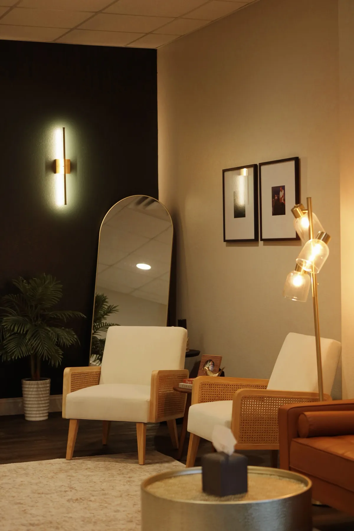 Lounge seating with cane chairs, an arched mirror and warm lamplight
